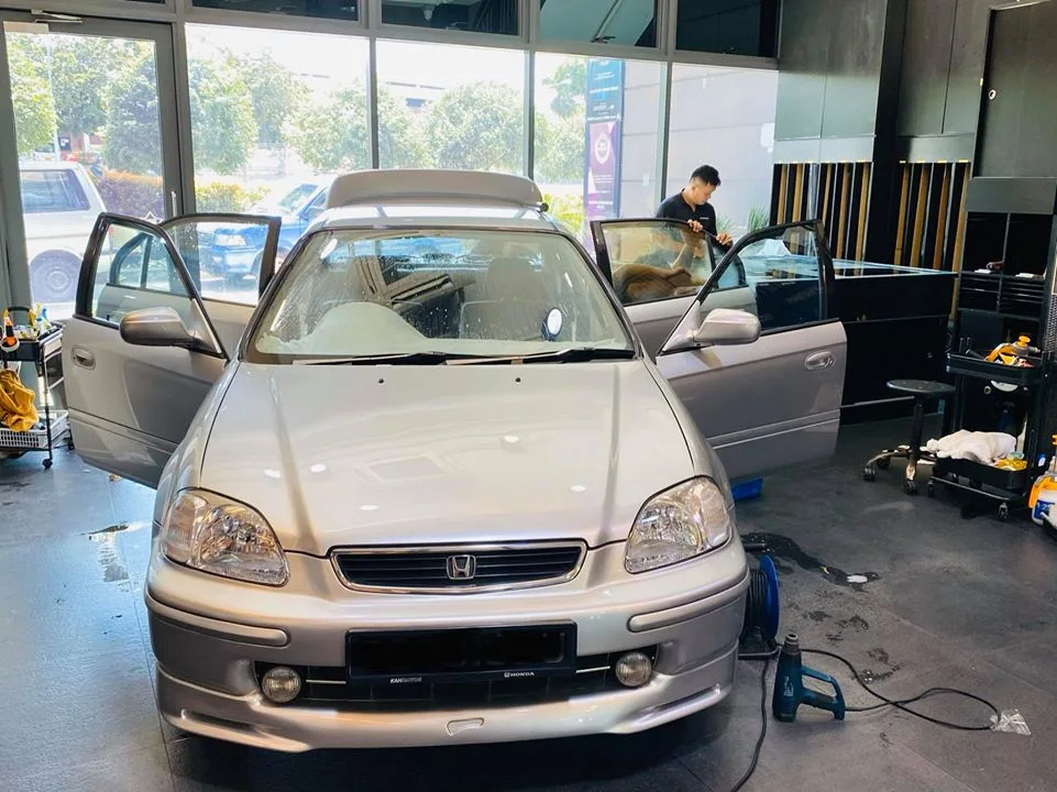 Silver Honda Civic with doors open during window tinting at Infratint Singapore