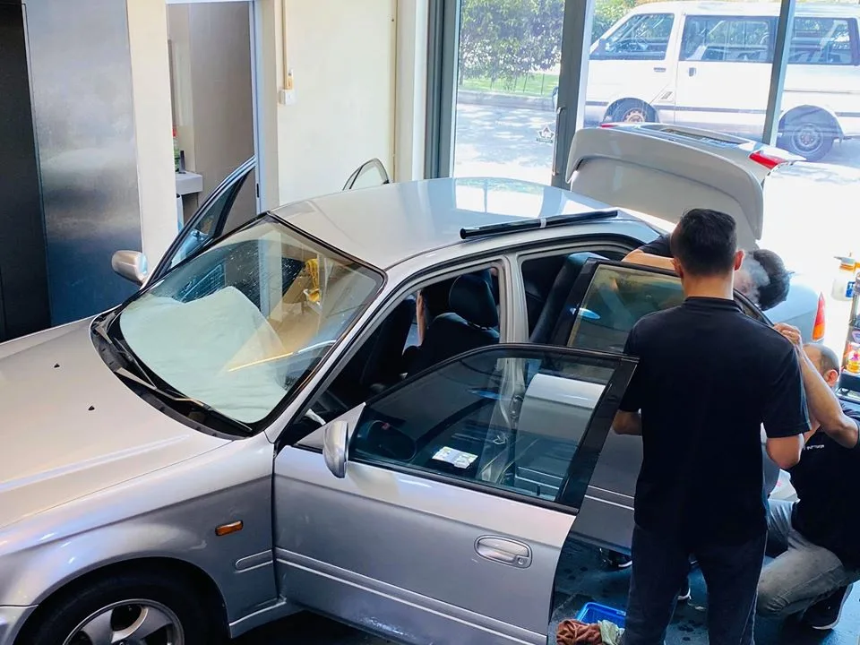 Silver Honda Civic hatchback being tinted with doors open at Infratint Singapore