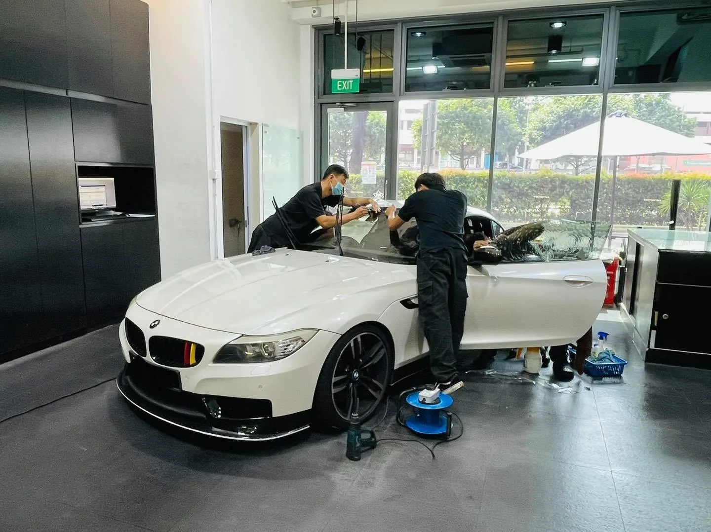 Installers tinting a white BMW Z4 roadster at Infratint Singapore