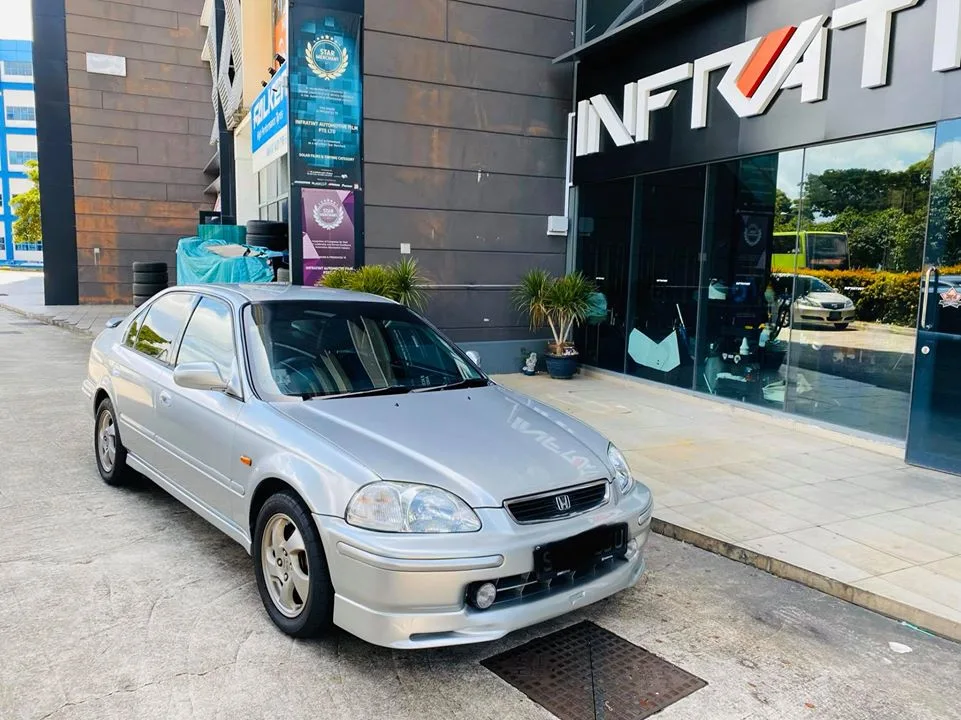 Silver Honda Civic sedan parked outside the Infratint Singapore shopfront for window tinting