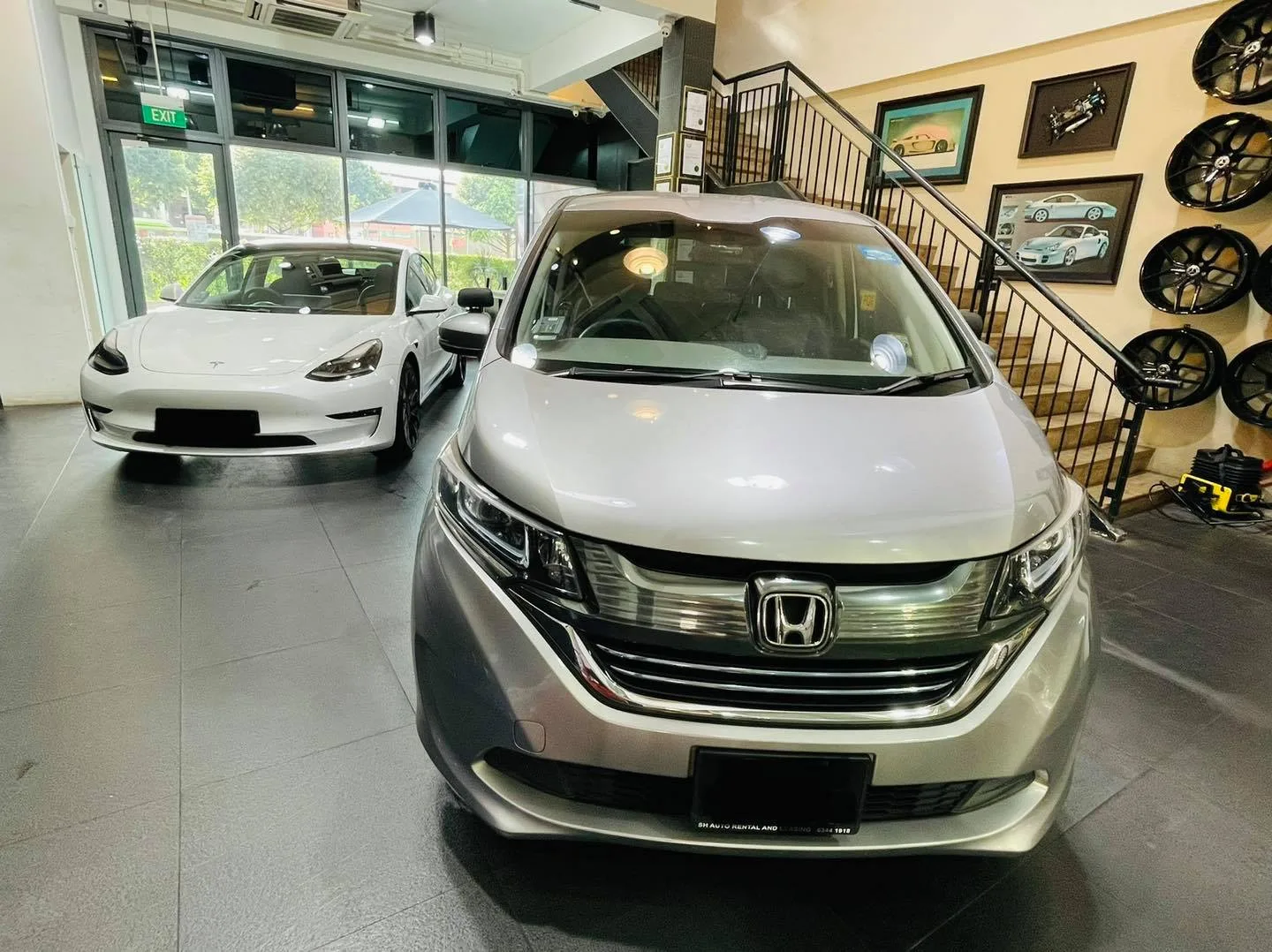 Silver Honda Freed and white Tesla Model 3 in the showroom at Infratint Singapore