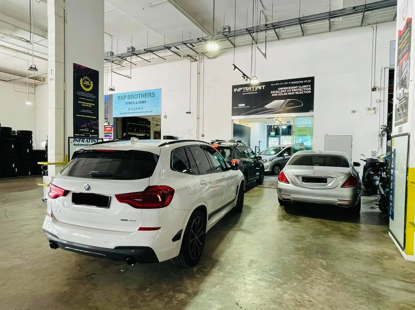 White BMW X3 rear view beside a silver Mercedes-Benz at Infratint Singapore