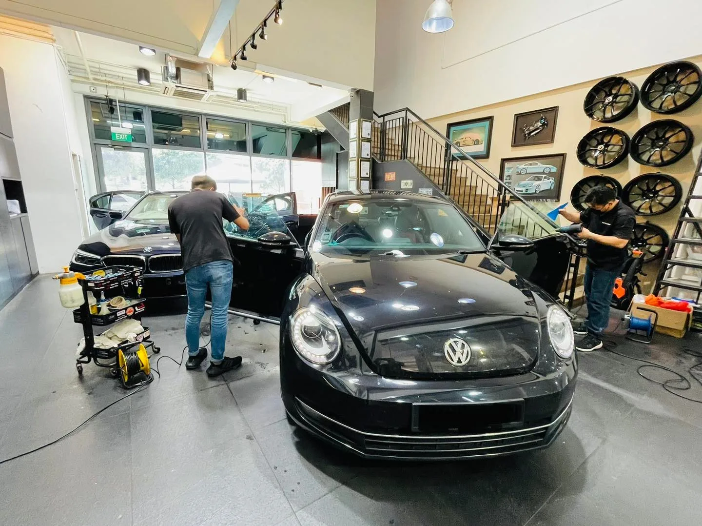 Black Volkswagen Beetle being tinted by installers at Infratint Singapore