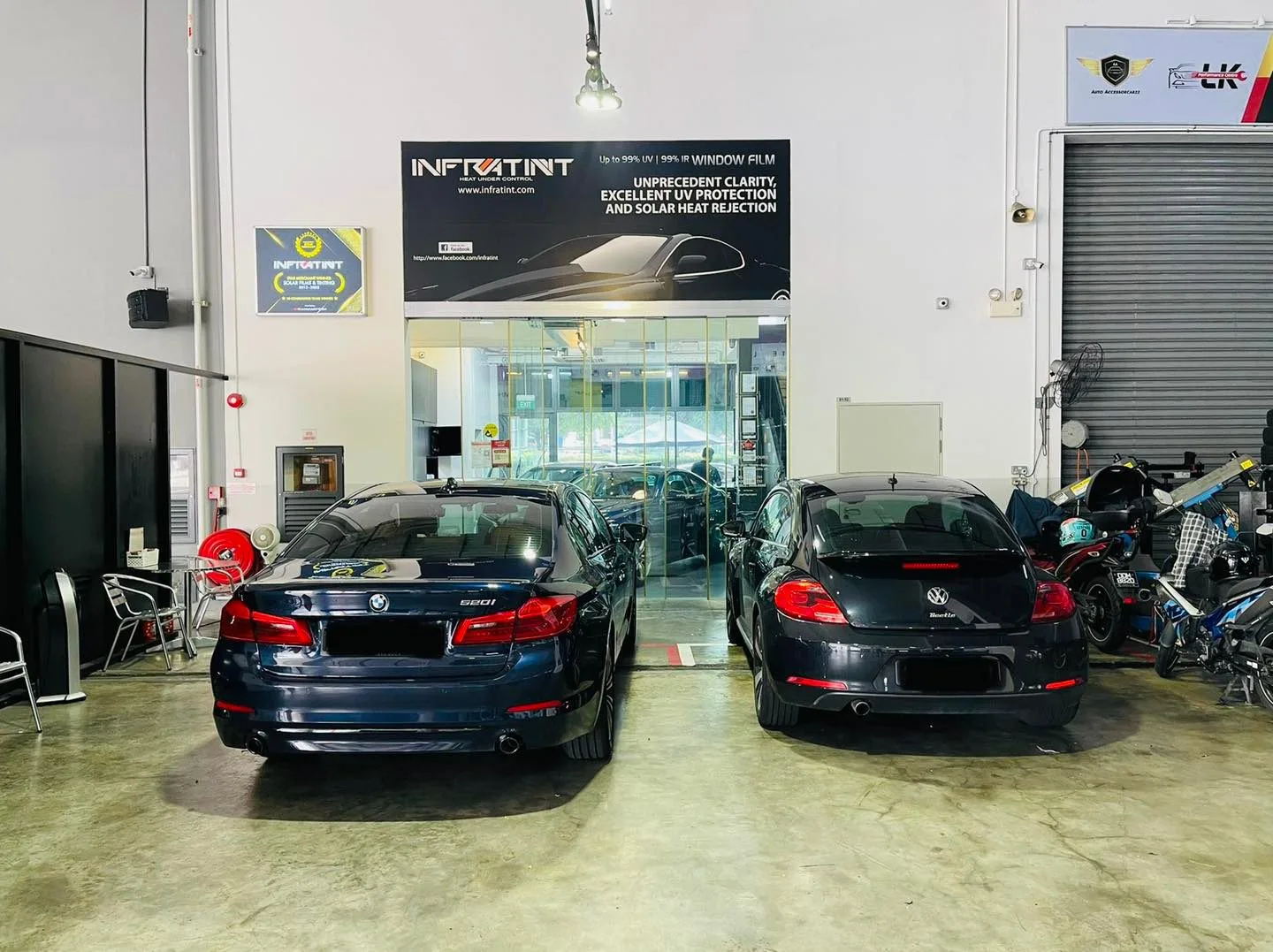 Blue BMW sedan and dark Volkswagen Beetle in the install bay at Infratint Singapore