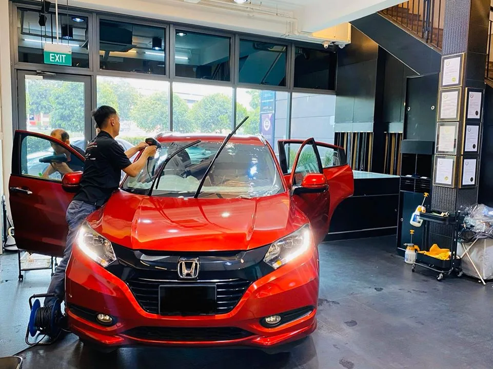 Red Honda HR-V SUV having windshield film squeegeed at Infratint Singapore
