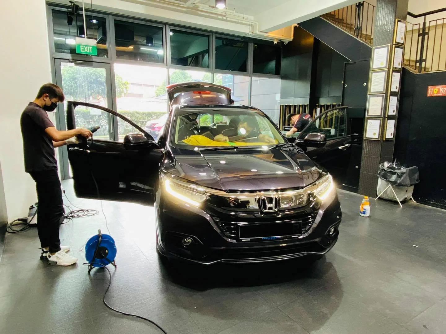 Installer applying window film to a black Honda HR-V at Infratint Singapore
