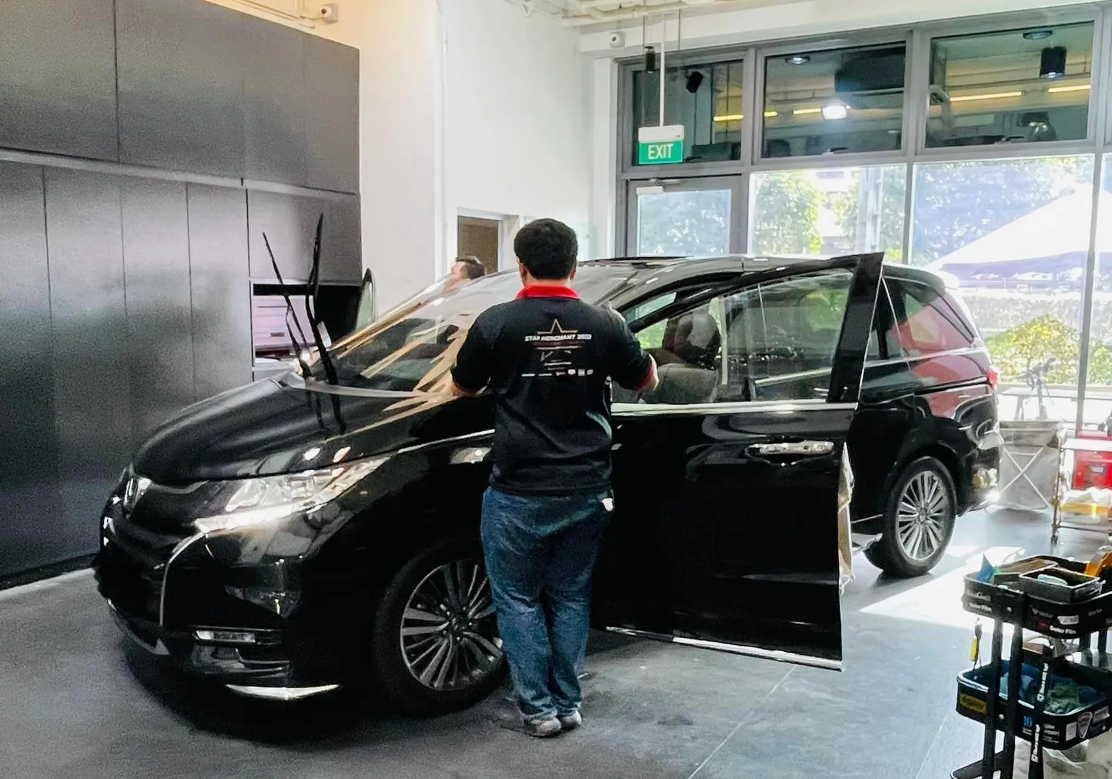 Black Honda Odyssey with sliding door open during window tinting at Infratint Singapore