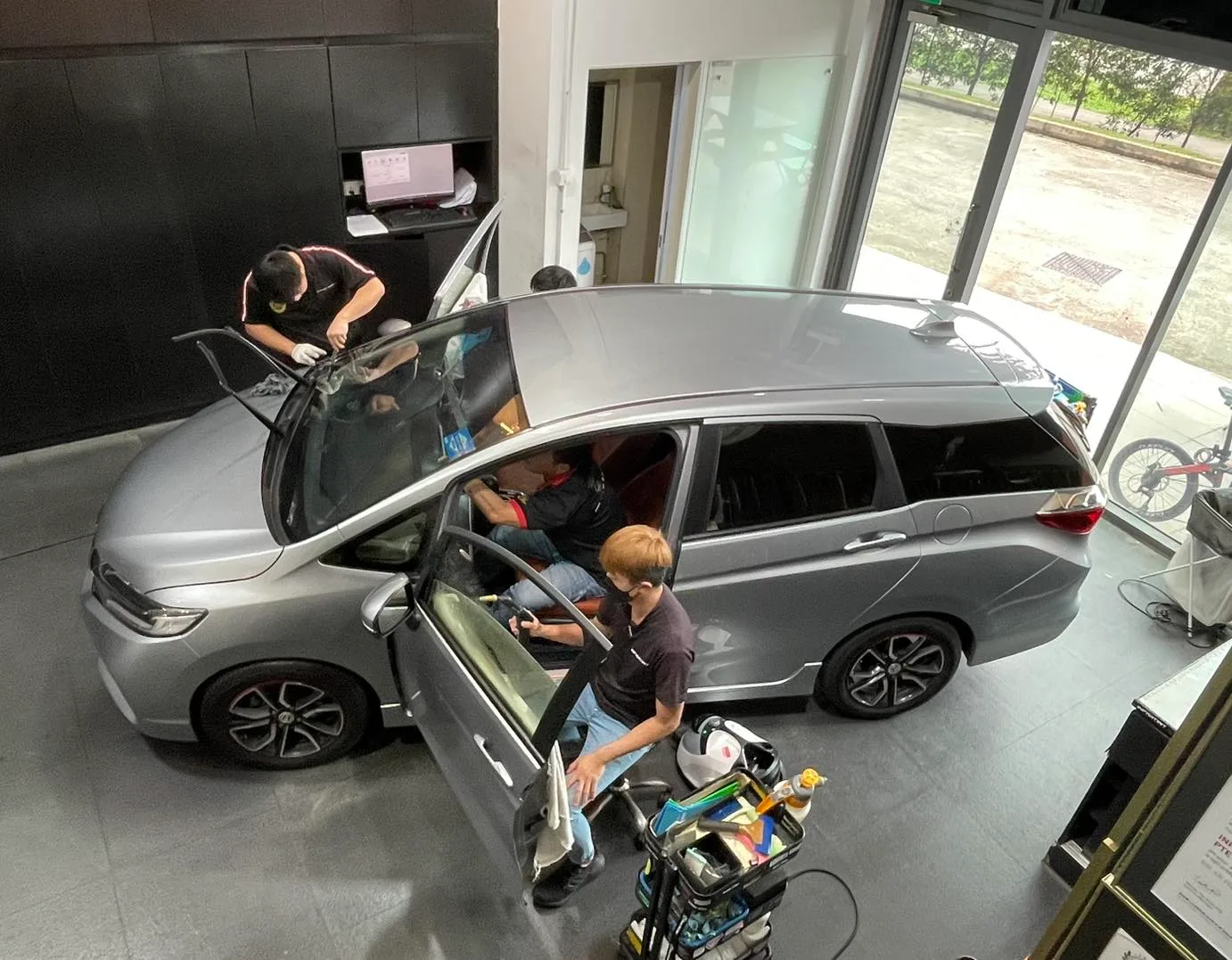 Overhead view of a silver Honda Shuttle being tinted by technicians at Infratint Singapore