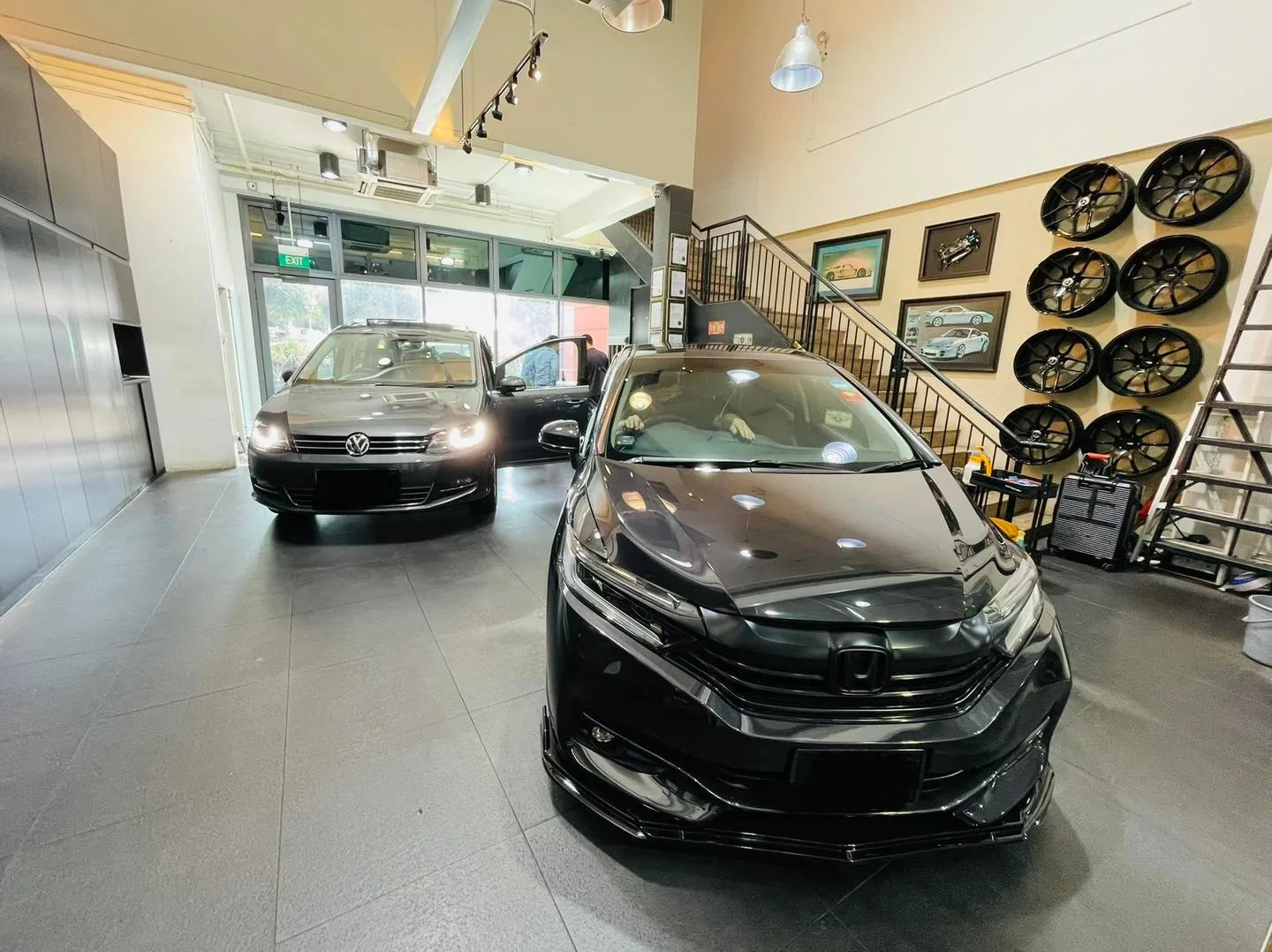 Black Honda Shuttle and white Volkswagen inside the Infratint Singapore showroom for window tinting