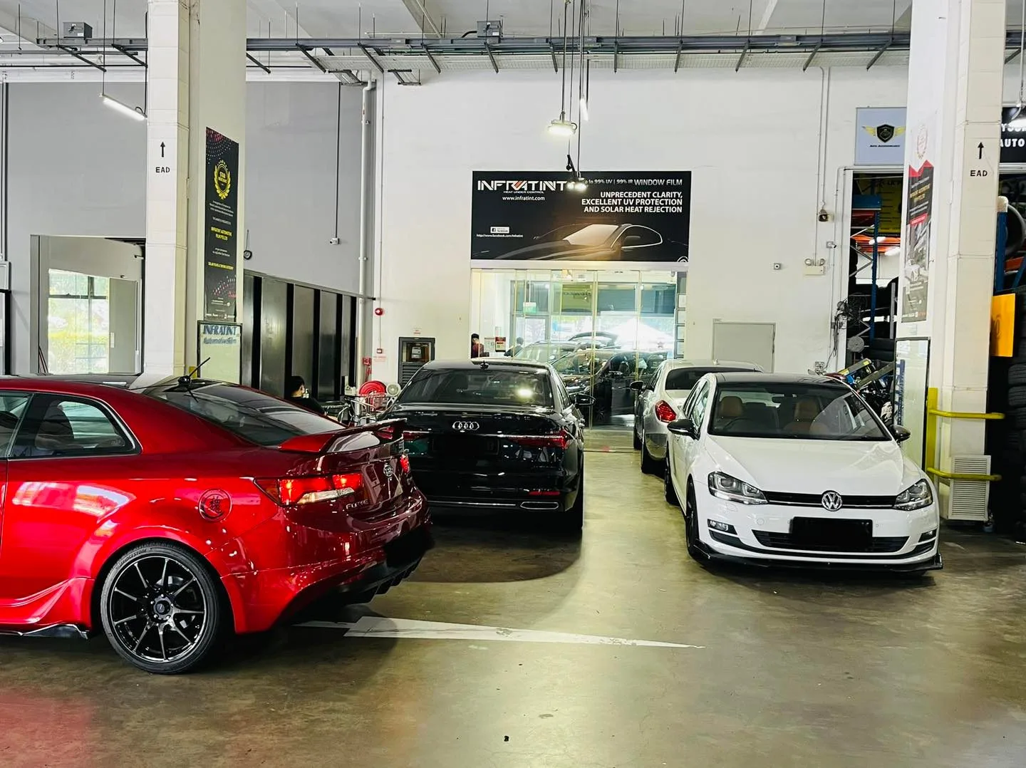 Red Audi RS, white Volkswagen Golf and a dark Audi lined up at Infratint Singapore