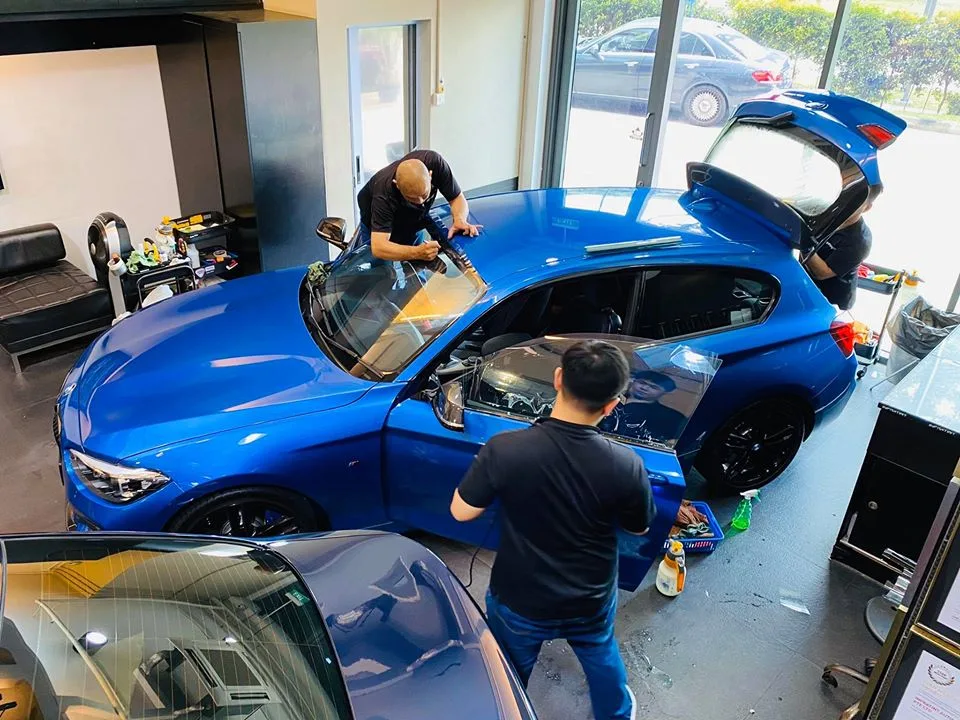 Blue BMW hatchback being tinted from overhead at Infratint Singapore