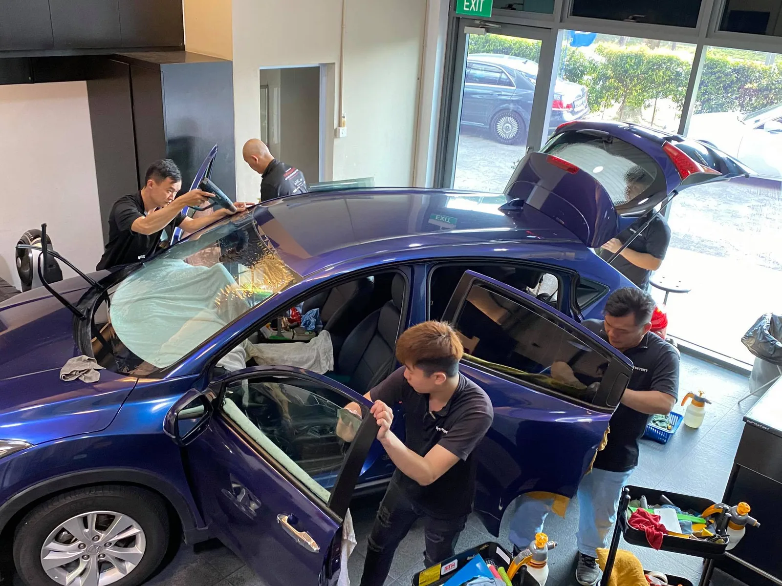 Team applying window film across a blue Honda Vezel at Infratint Singapore