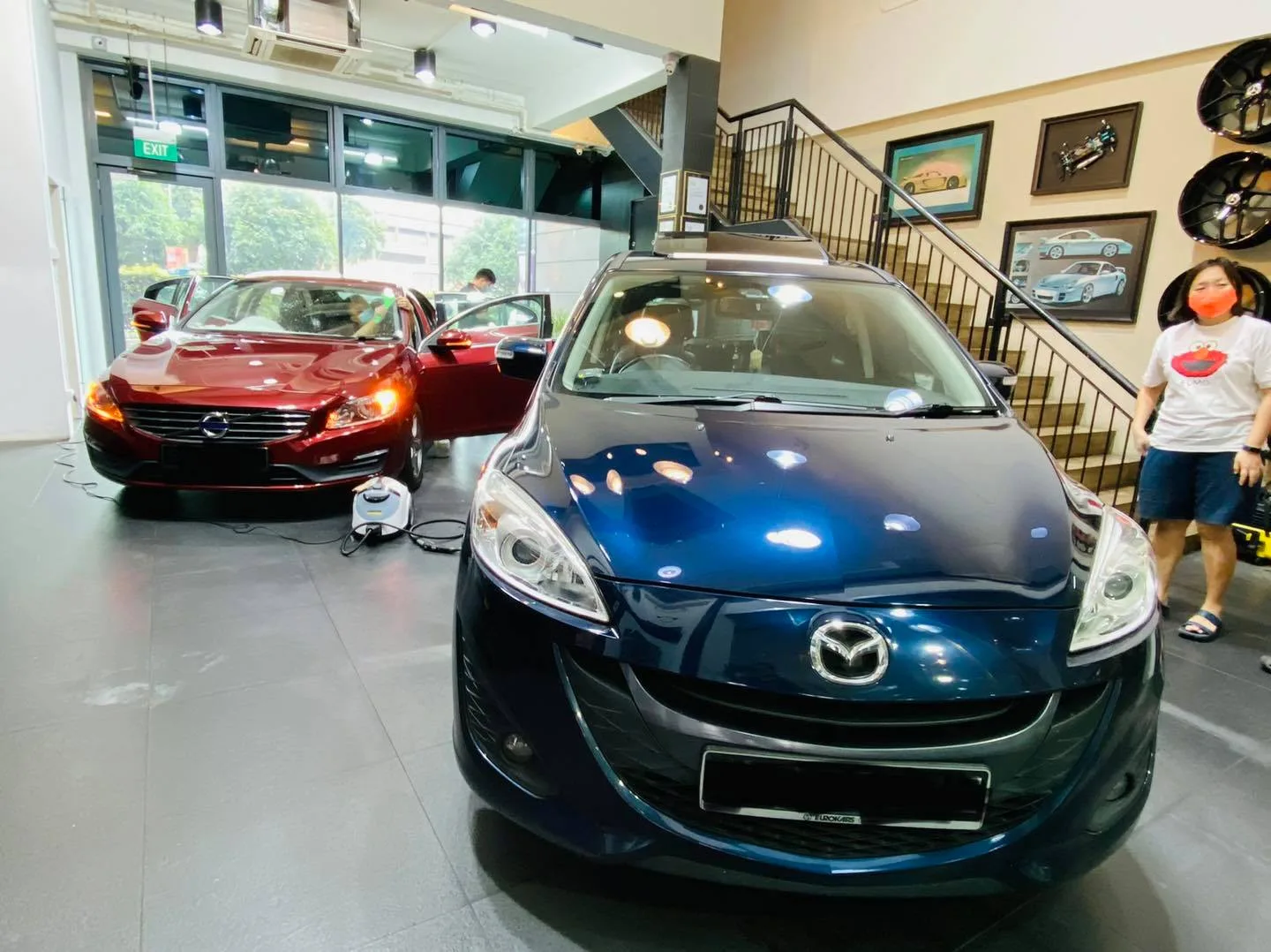 Blue Mazda 5 MPV and red Volvo S60 inside the Infratint Singapore showroom