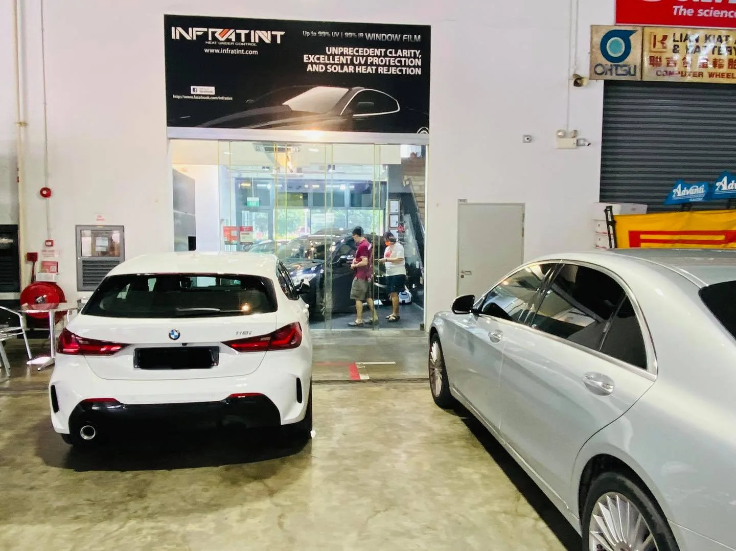 White BMW 118i and white Mercedes-Benz S-Class in the Infratint Singapore workshop