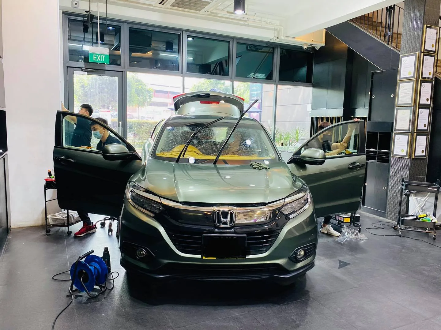 Green Honda SUV with doors open during window tinting at Infratint Singapore