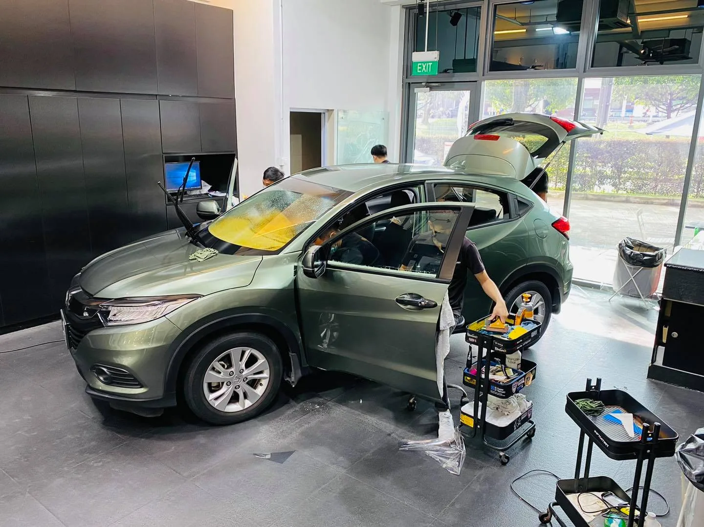 Installer working on a green Honda SUV with tailgate open at Infratint Singapore