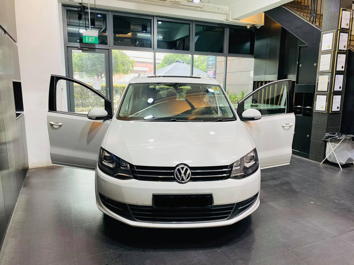 White Volkswagen Sharan MPV being prepared for window film at Infratint Singapore