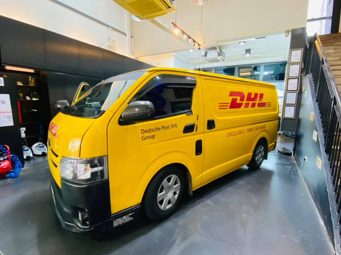 Side view of a yellow DHL Toyota Hiace van at Infratint Singapore for window film