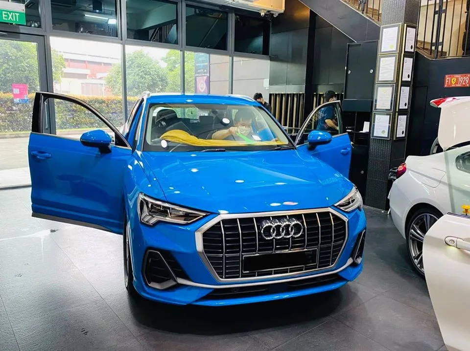 Blue Audi Q3 SUV with door open during window tinting at Infratint Singapore