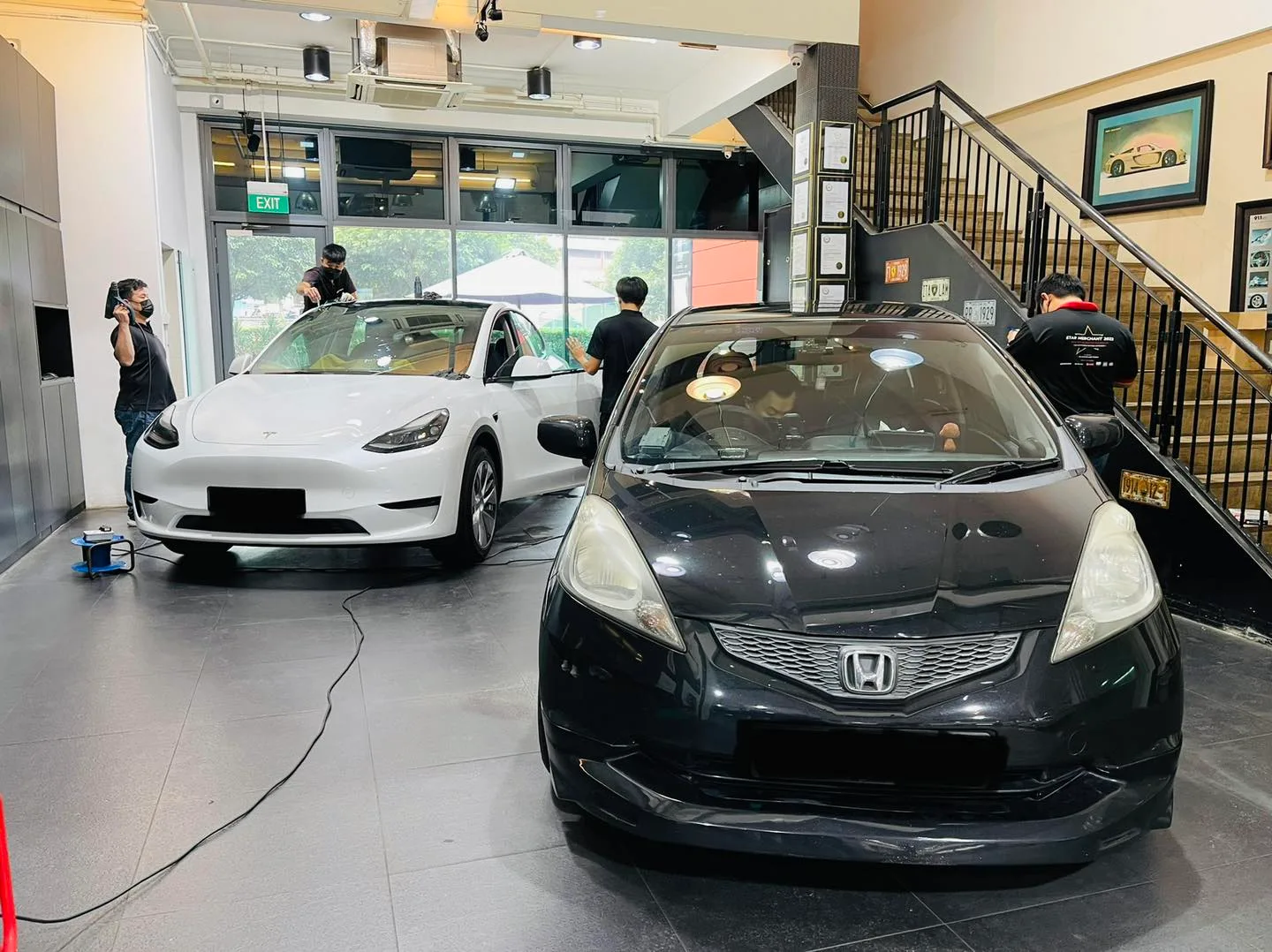 White Tesla Model Y and black Honda inside the Infratint Singapore showroom