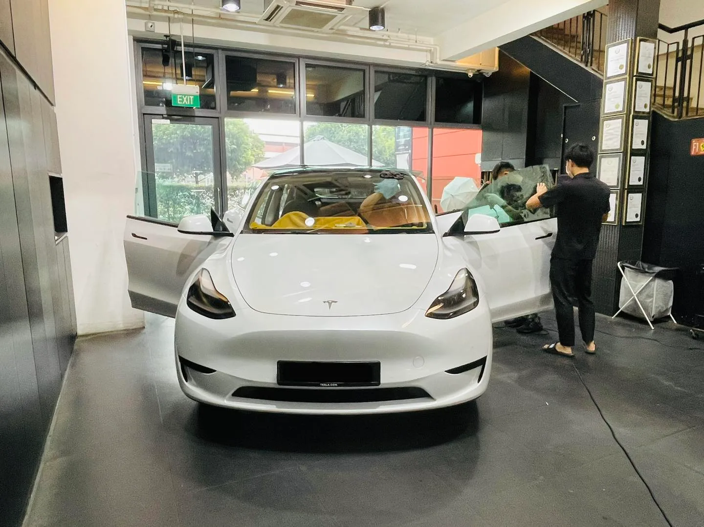 White Tesla Model Y with tan interior during tinting at Infratint Singapore