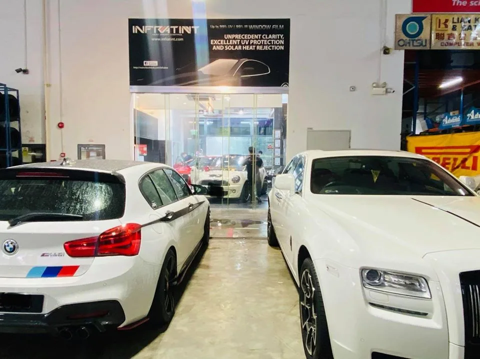 White BMW 1 Series and white Rolls-Royce inside Infratint Singapore during window tinting