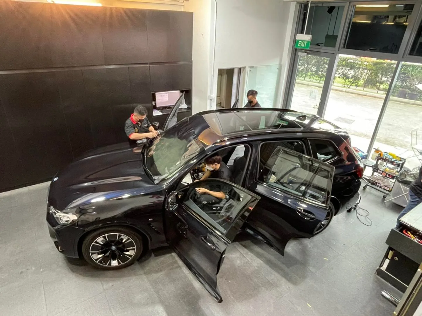 Overhead view of a black BMW SUV during window film installation at Infratint Singapore