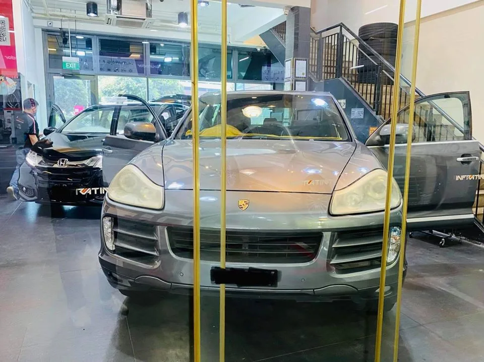 Grey Porsche Cayenne SUV viewed through glass at Infratint Singapore
