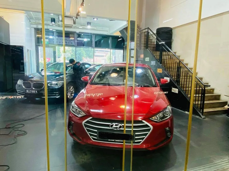 Red Hyundai Avante sedan and black BMW 5 Series at Infratint Singapore