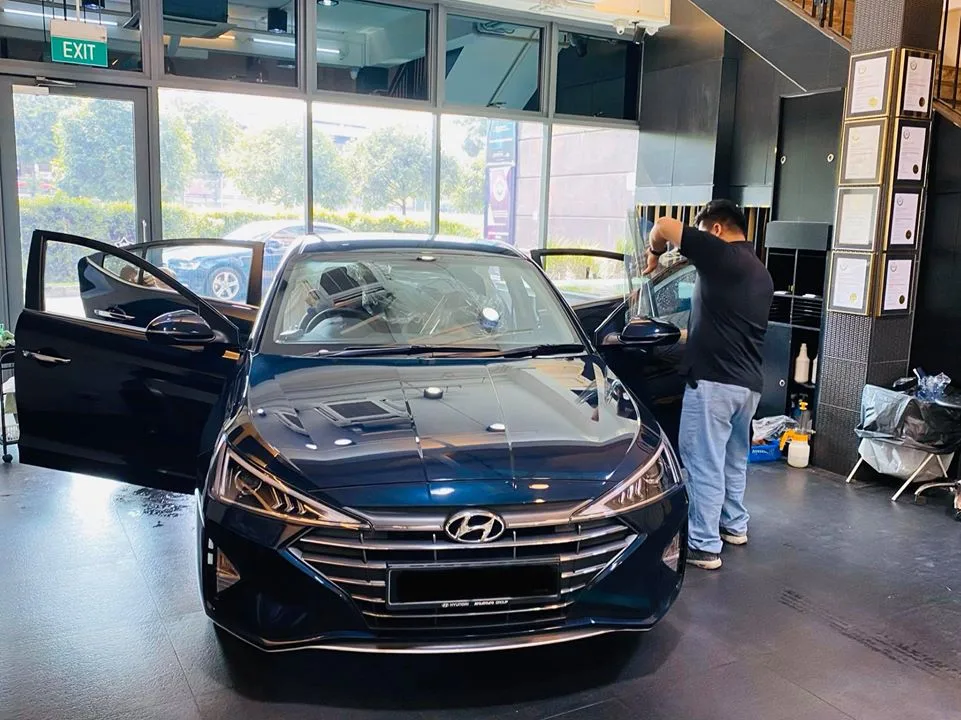 Dark blue Hyundai with doors open during window tinting at Infratint Singapore