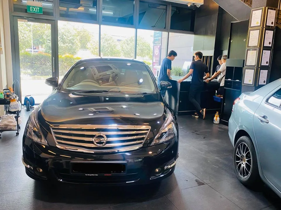Black Nissan Teana sedan front view inside the Infratint Singapore showroom