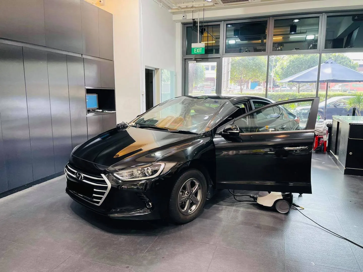 Black Hyundai Elantra with driver door open during window tinting at Infratint Singapore