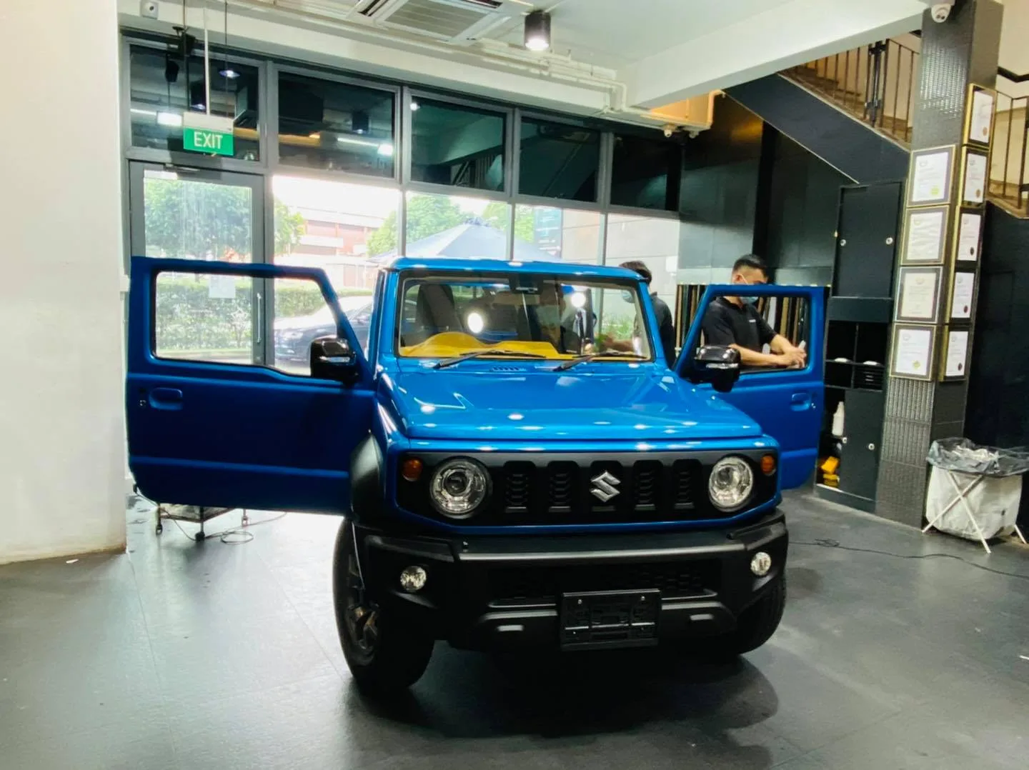 Blue Suzuki Jimny with front doors open during tinting at Infratint Singapore
