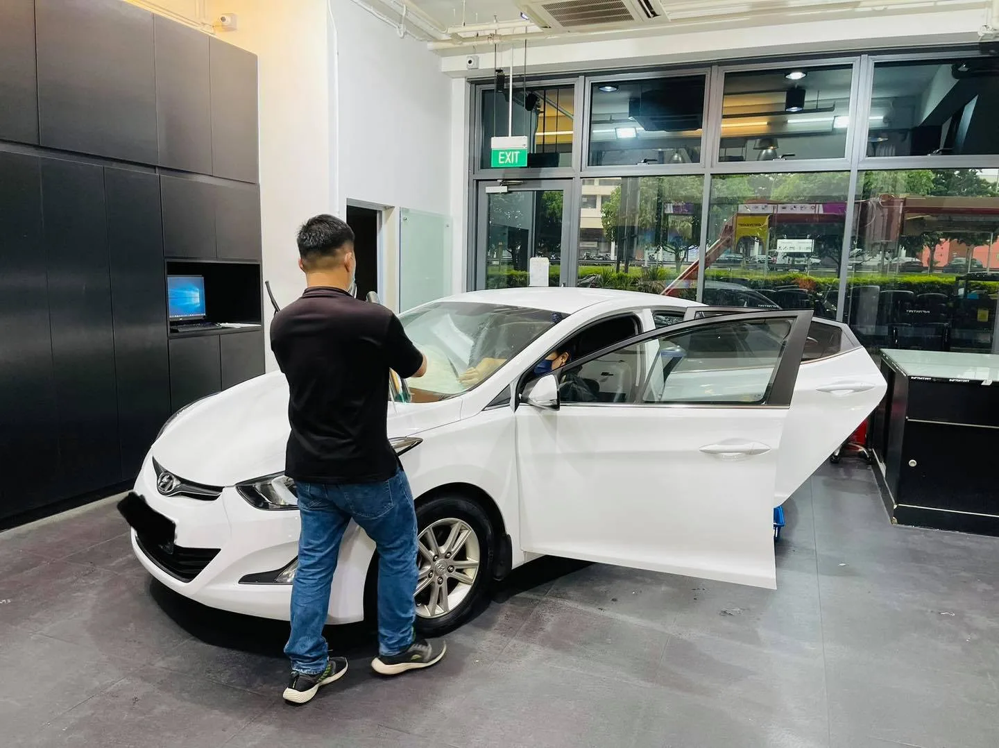 White Hyundai Elantra with front door open during window tinting at Infratint Singapore