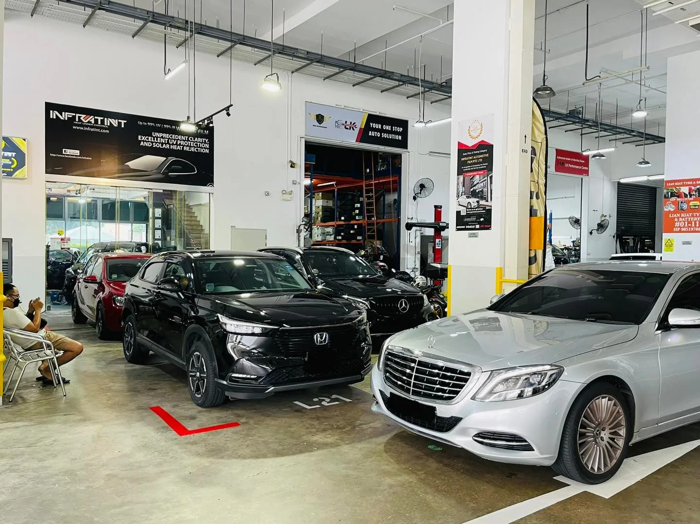 Black Honda SUV and silver Mercedes-Benz S-Class in the install bay at Infratint Singapore