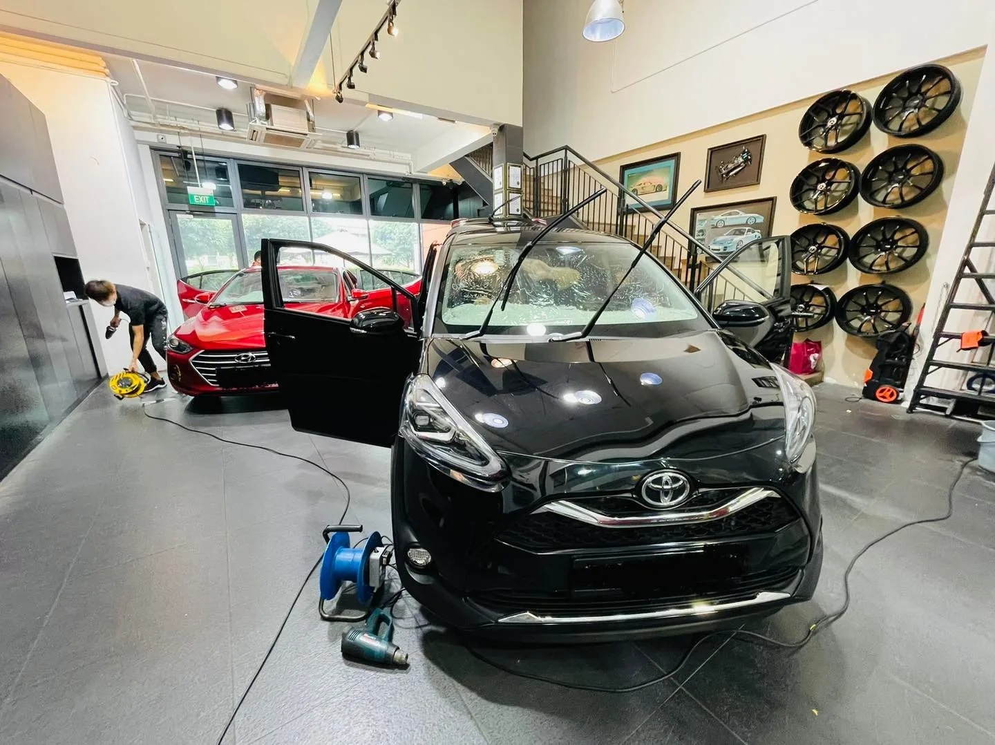 Black Toyota Sienta MPV being prepped for window tinting at Infratint Singapore