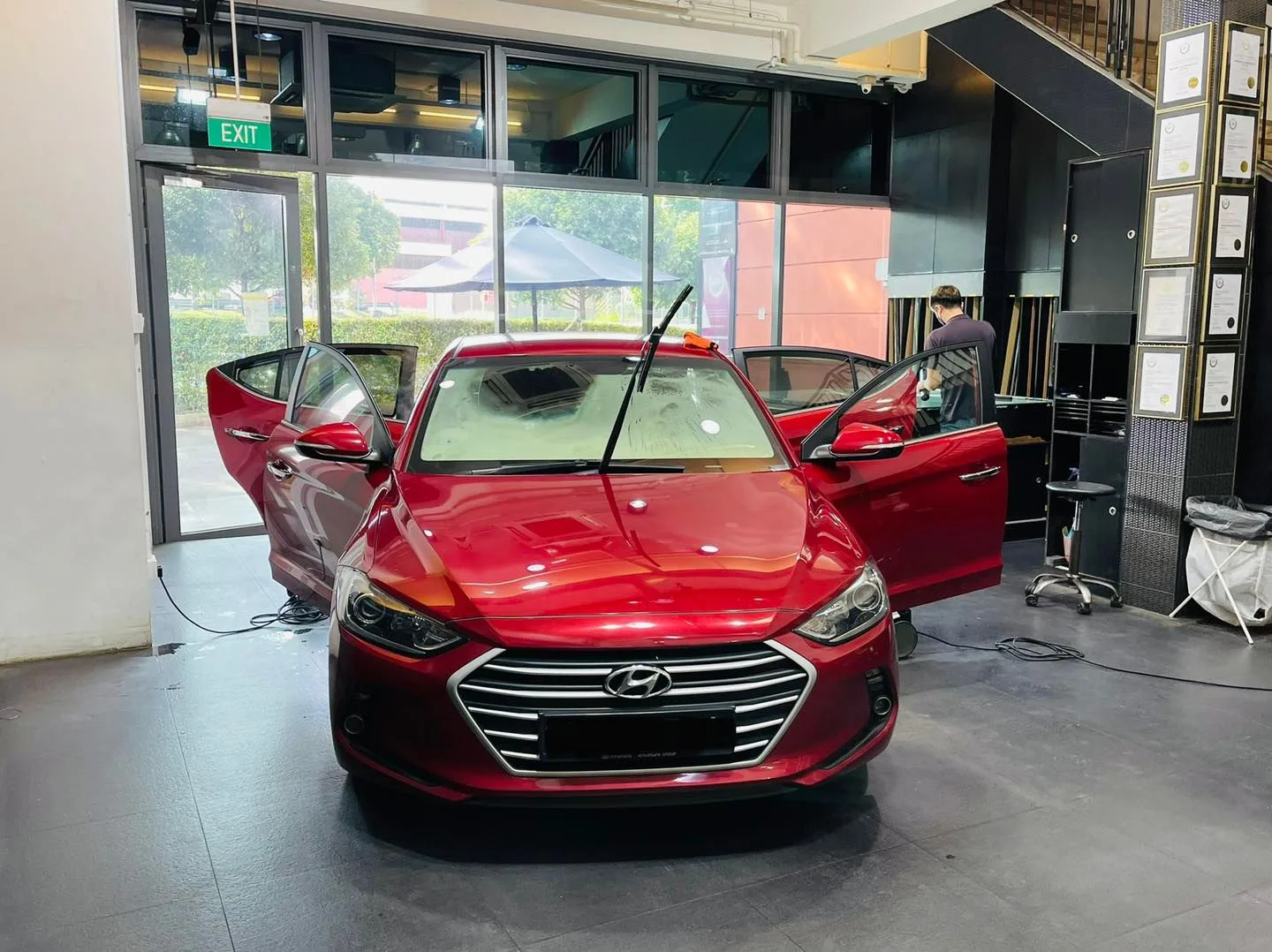 Red Hyundai Elantra with doors open during window tinting at Infratint Singapore