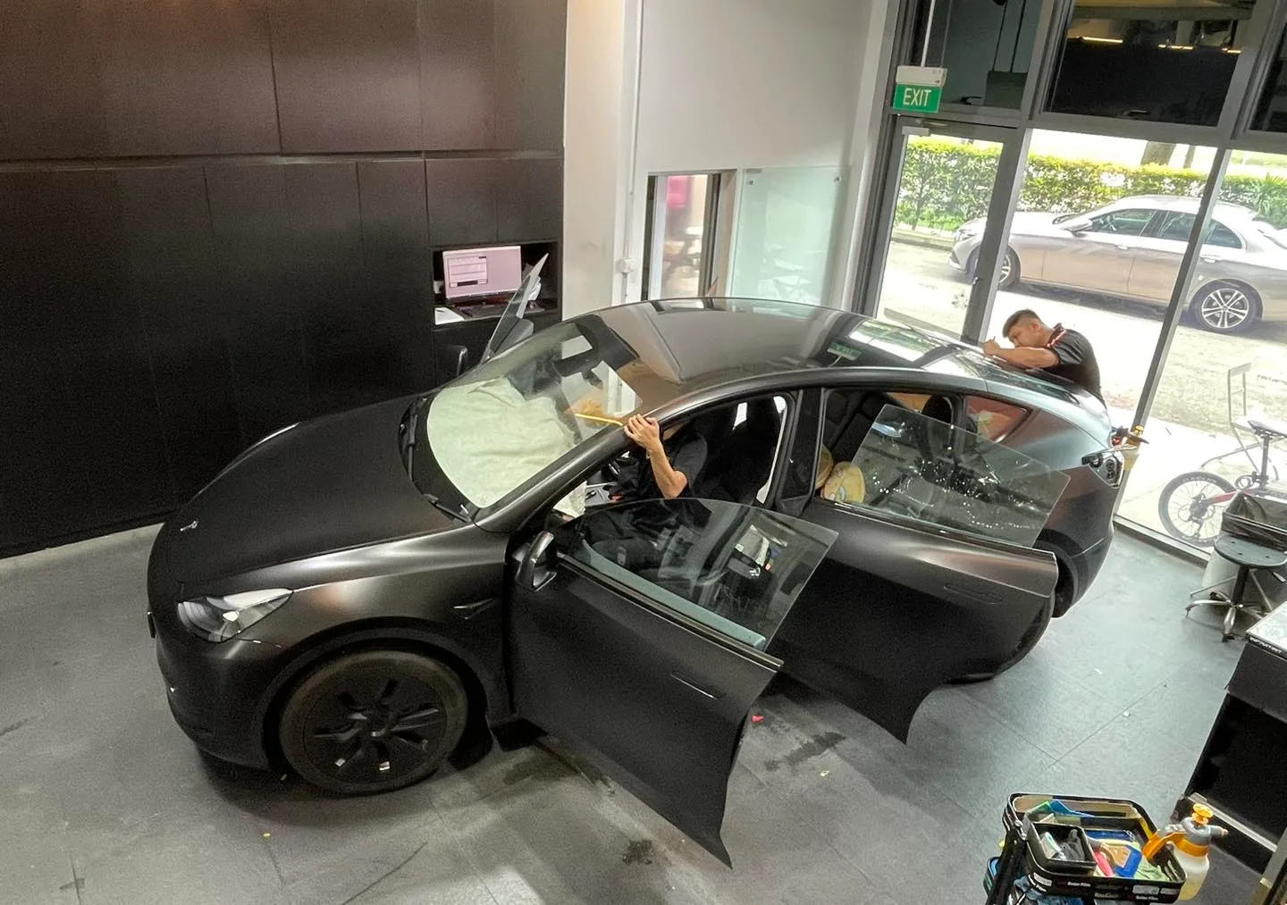 Matte black Tesla Model Y at a front three-quarter angle at Infratint Singapore