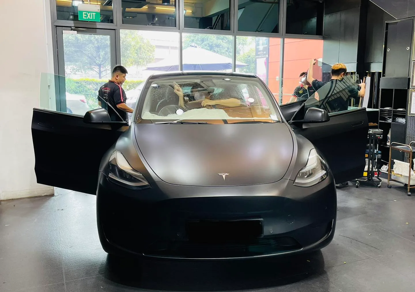 Technicians tinting a matte black Tesla Model Y windscreen at Infratint Singapore