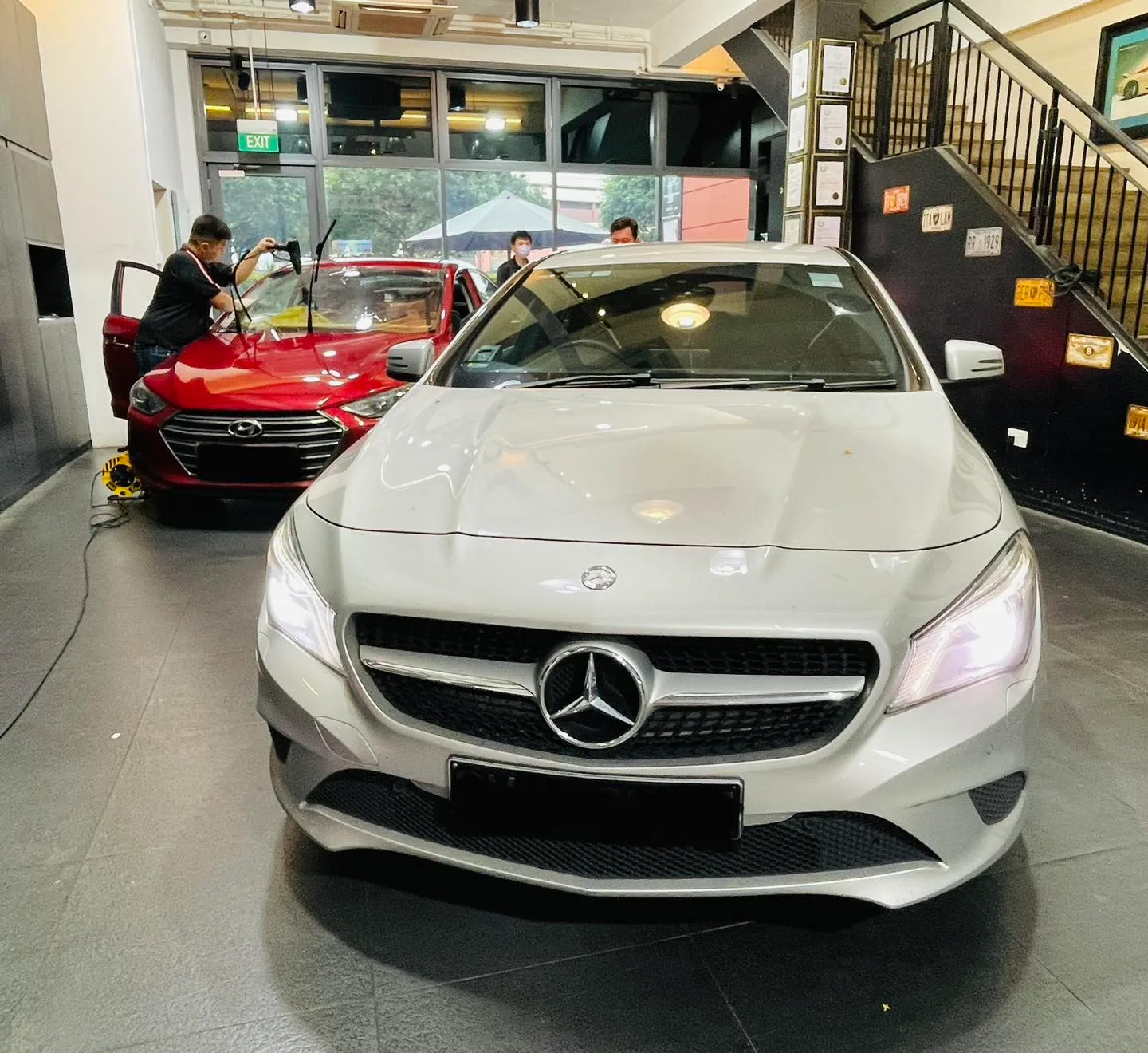 Silver Mercedes-Benz CLA and red Hyundai sedan at Infratint Singapore for window tinting