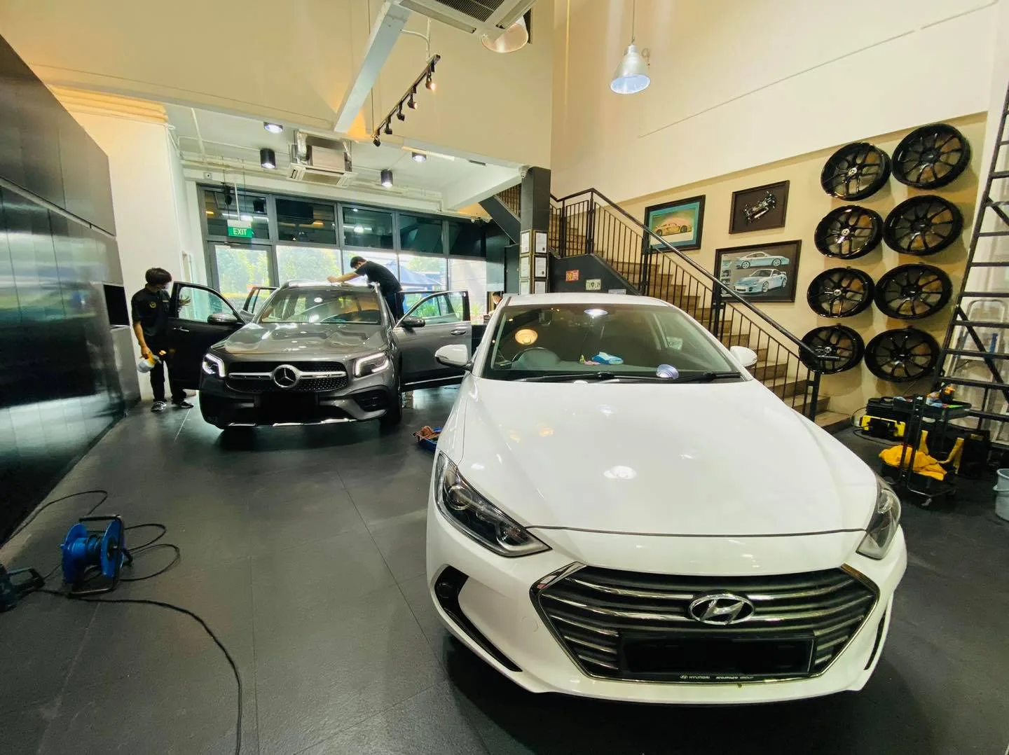 White Hyundai sedan and a grey Mercedes-Benz inside the Infratint Singapore showroom