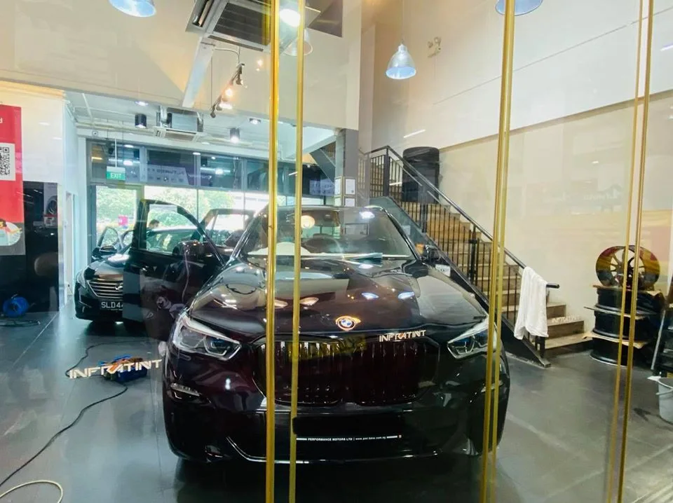 Maroon BMW SUV seen through the glass doorway at Infratint Singapore