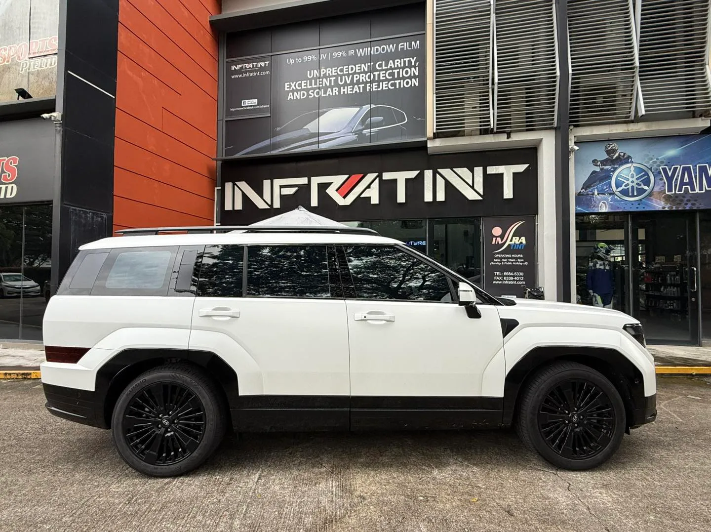 White Hyundai Santa Fe side profile outside Infratint Singapore signage