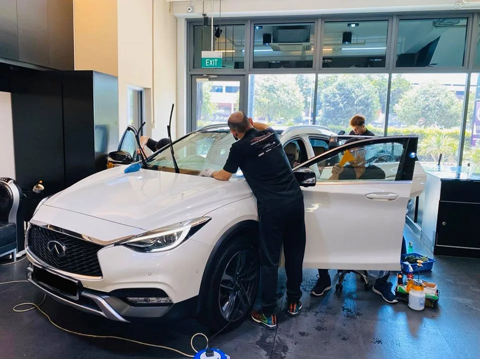 White Infiniti Q30 during window tinting with doors open at Infratint Singapore