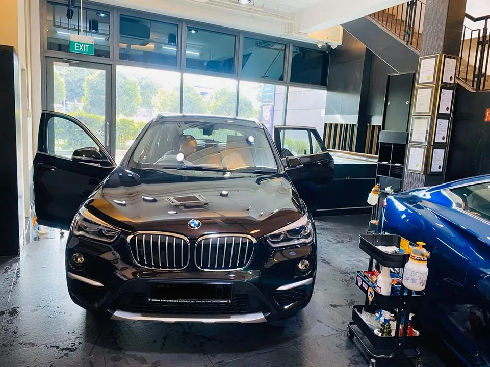 Black BMW X1 with doors open ready for window film at Infratint Singapore