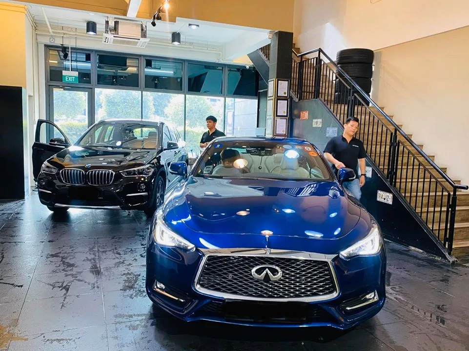 Blue Infiniti Q60 and black BMW X1 inside Infratint Singapore for window tinting