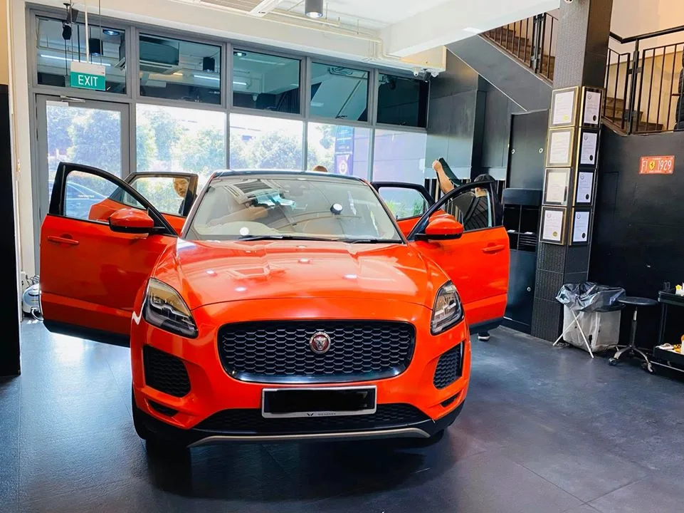 Orange Jaguar E-PACE with doors open being prepped for window tinting at Infratint Singapore