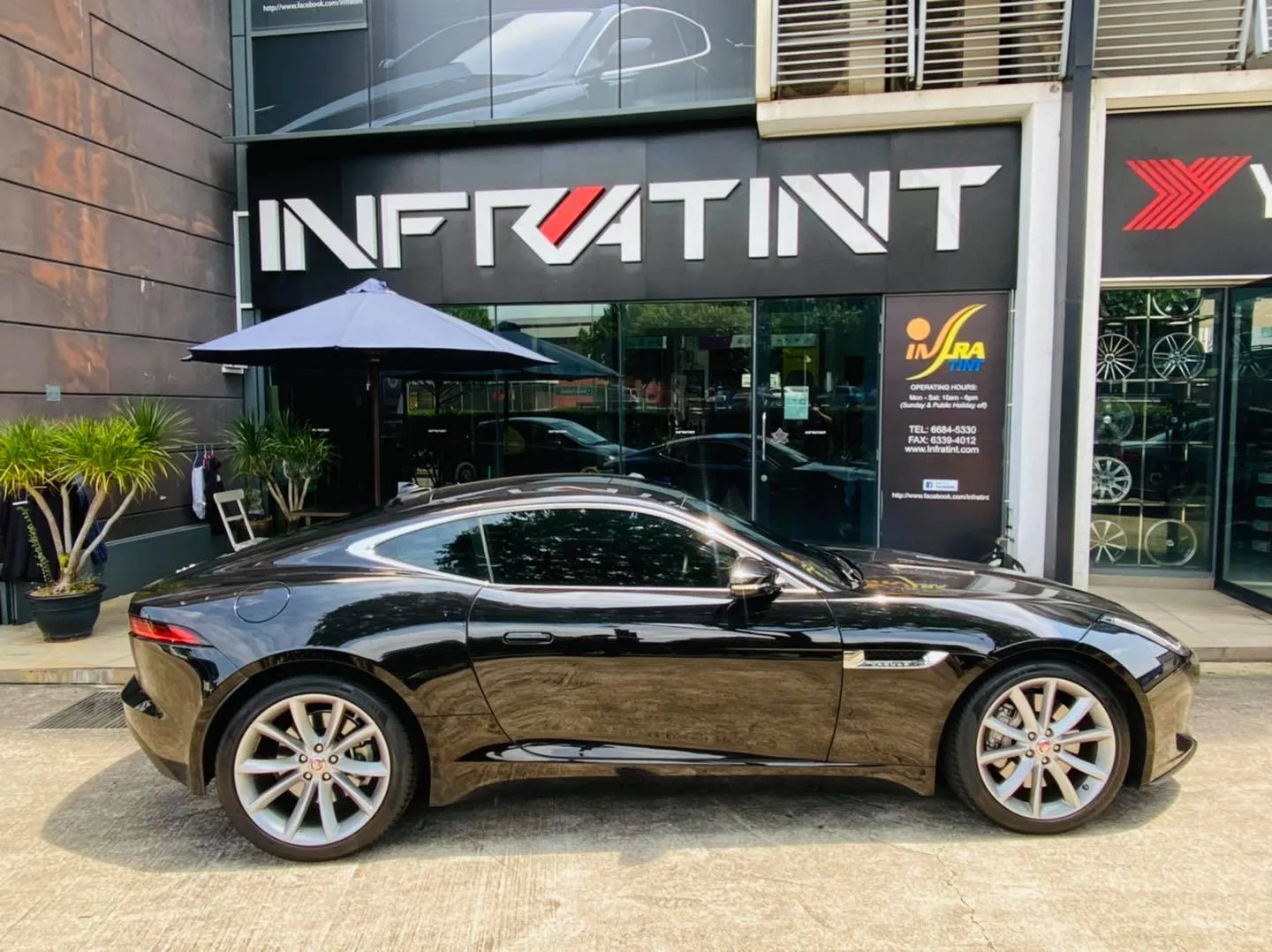 Black Jaguar F-Type in profile below the Infratint Singapore sign