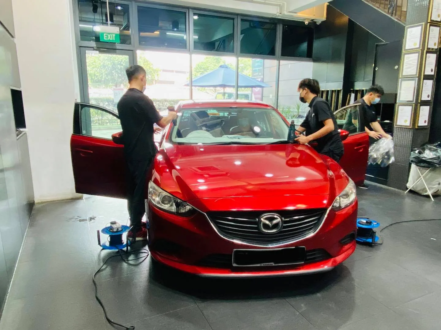 Red Mazda6 sedan being tinted by three installers at Infratint Singapore
