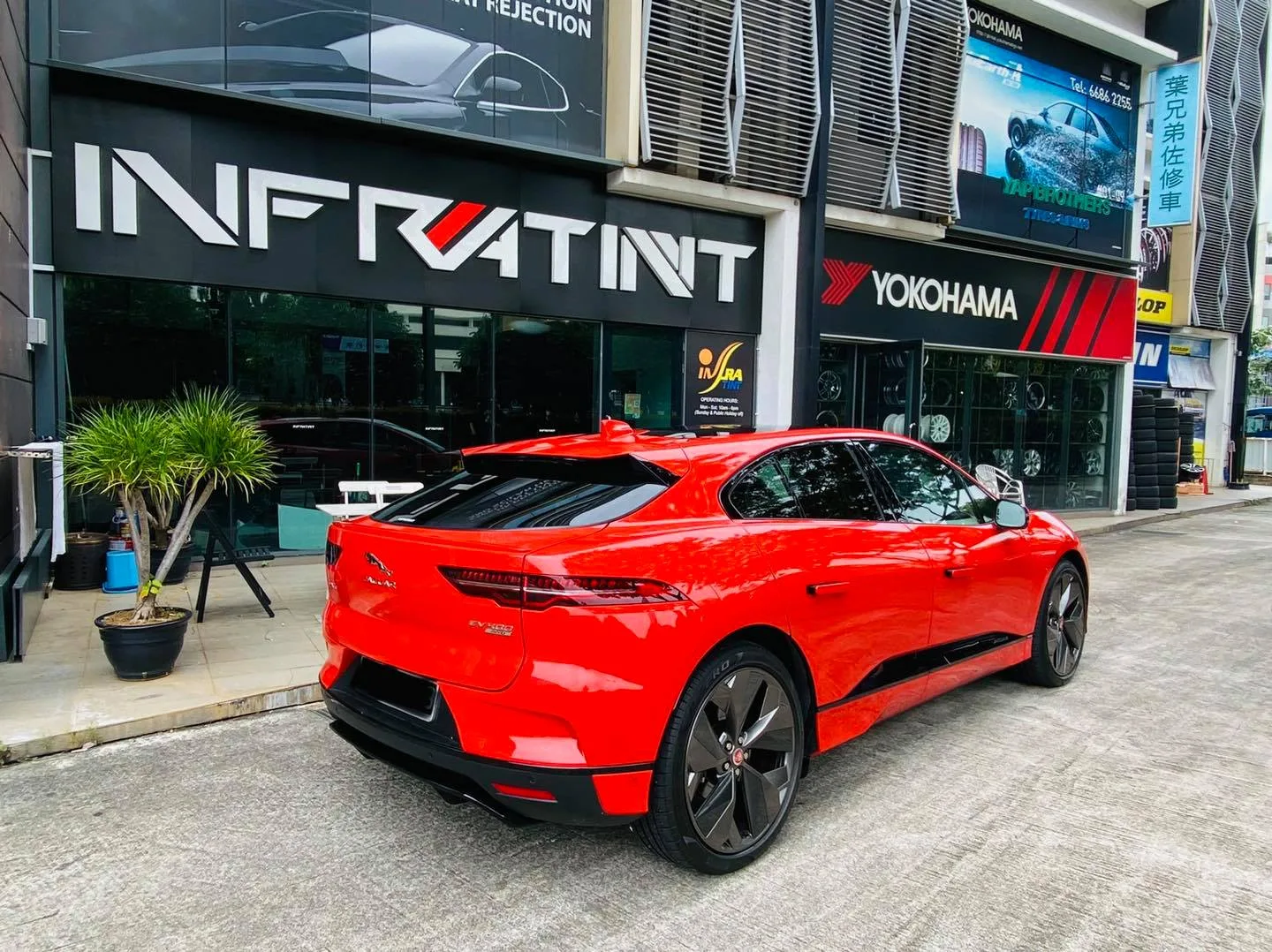 Red Jaguar I-Pace rear three-quarter view at the Infratint Singapore shopfront